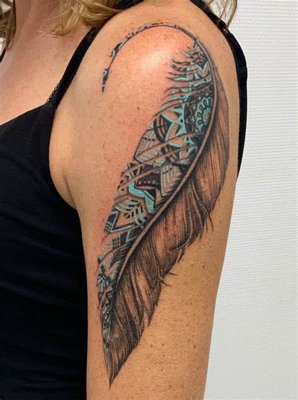 Tatouage plume avec des nuances de turquoise sur le haut de l'épaule